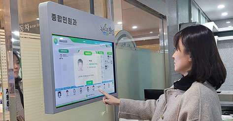 벽면부착형 스마트조직안내 키오스크를 조작하고 있는 직원모습